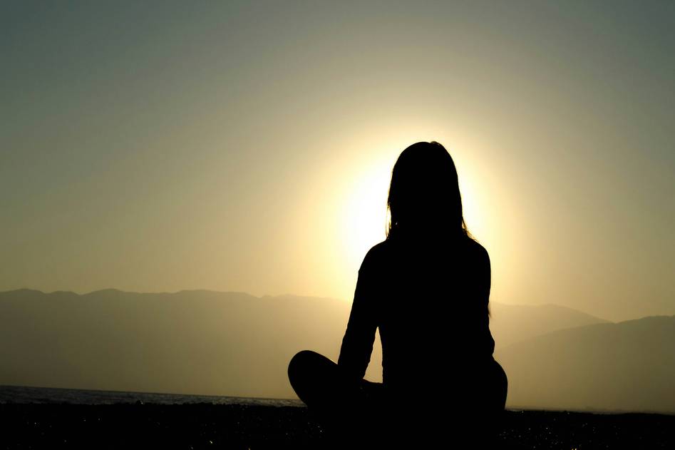 Calm beginner meditating on cushion in soft natural light